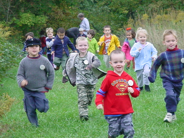 Children running along a grassy trail